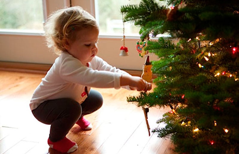 nino en arbol de navidad