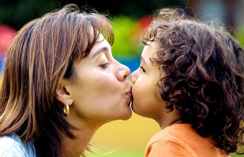 besar a niño en la boca