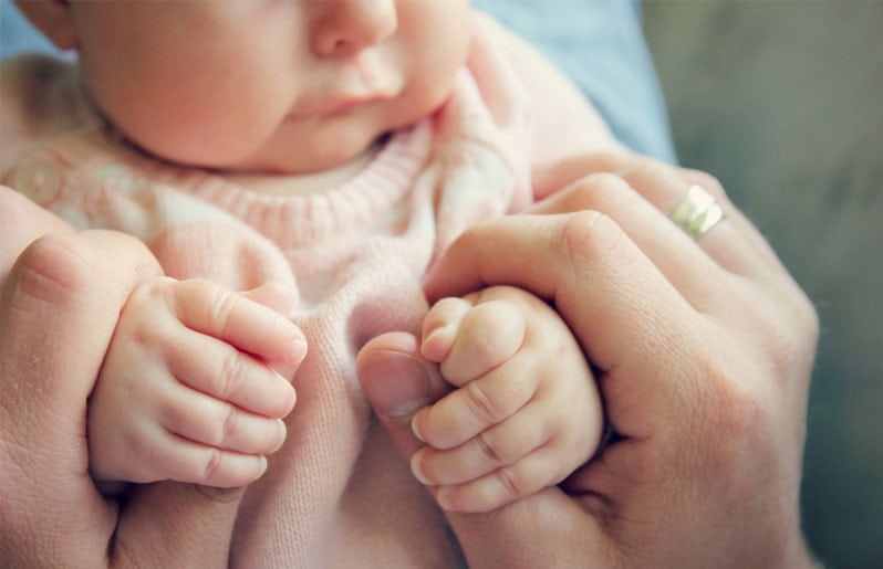 mama agarrando las manos de su bebe