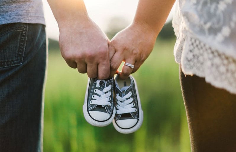 pareja cargando tenis de su hijo