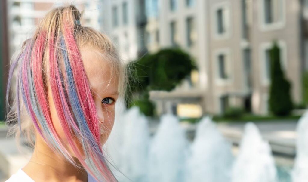 niña con peinado de coleta y mechones de colore